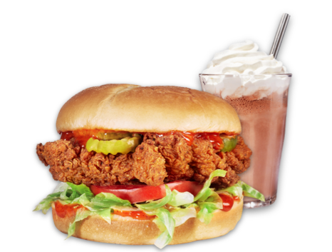 A fried chicken sandwich with a milkshake next to it.